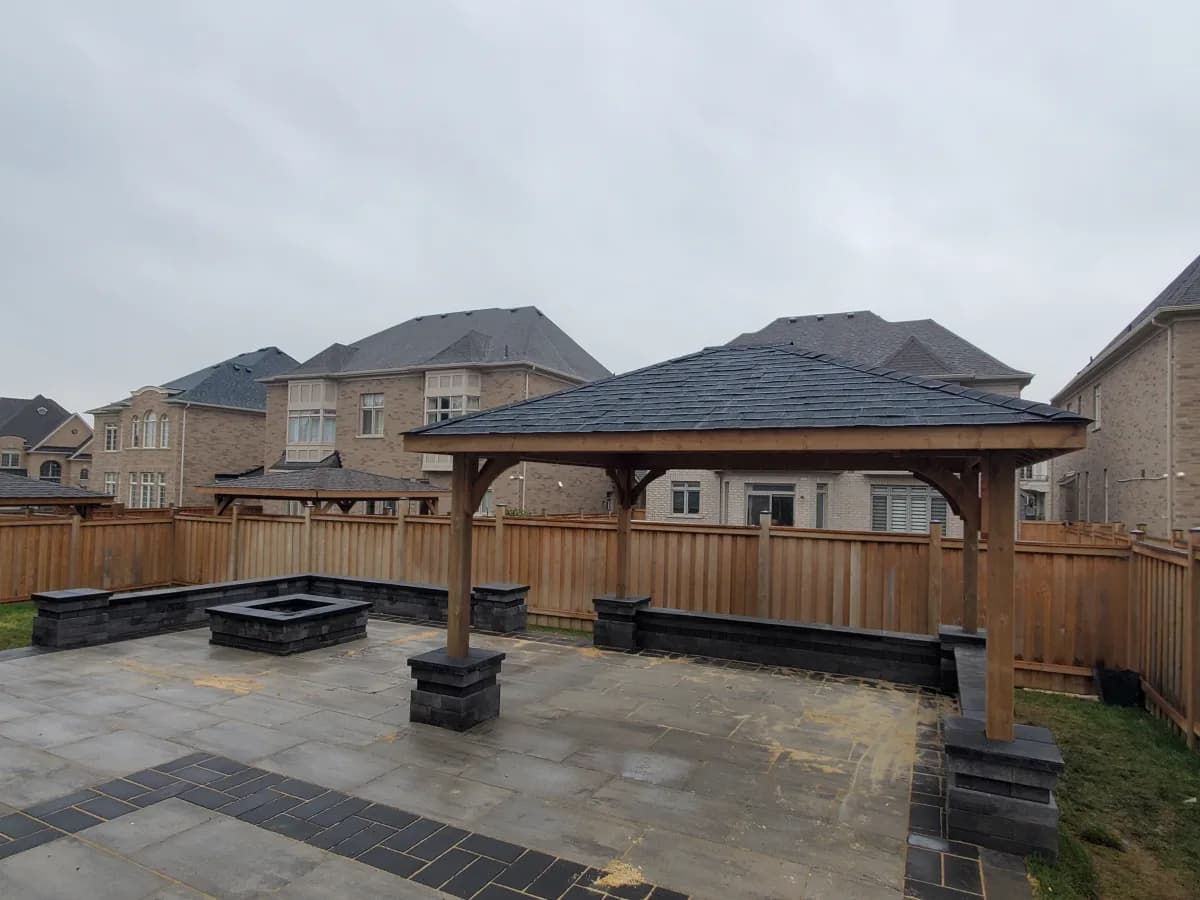 A backyard pergola under construction with tools and materials around