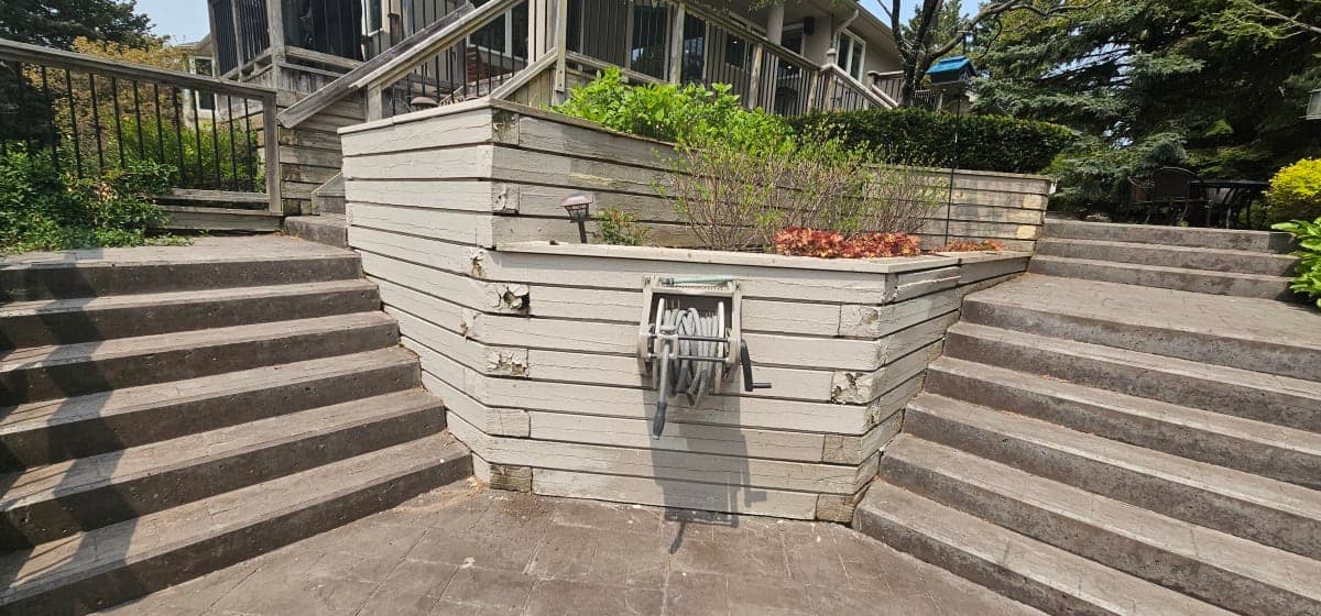A sturdy retaining wall built with concrete blocks in a snowy Canadian backyard