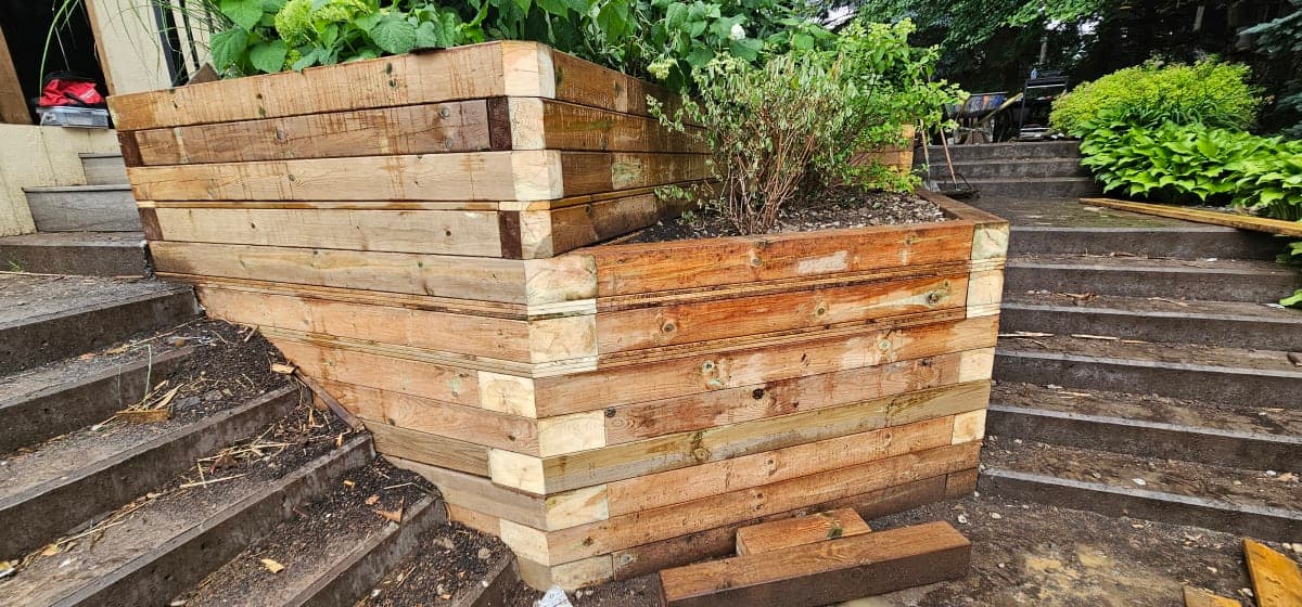Retaining wall construction site with gravel base and stacked blocks
