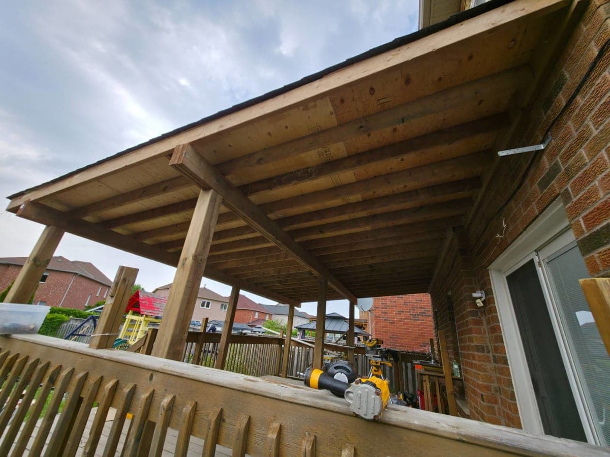 Roof installation in progress with workers and materials on site in spring