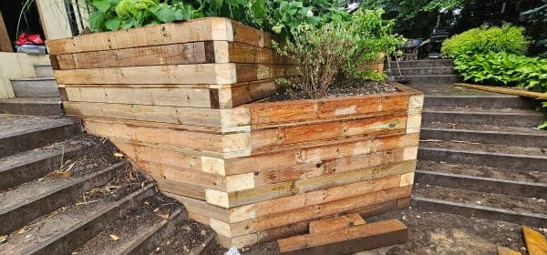 A construction crew building a retaining wall on a prepared and marked site in spring