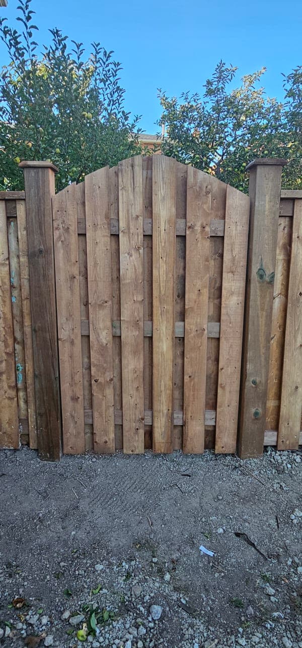 Wooden gate in a wet and snowy environment showing frost heave prevention measures